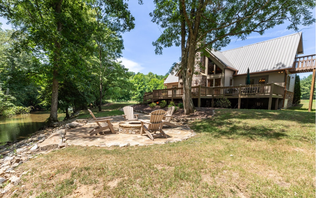 You know you MUST SEE this lovely riverfront home with a name like Memory Lane! Tucked at the back of the lot close to the Nottely River, you’ll find yourself spending time outdoors fishing in the river, grilling on the huge back deck, or gathered around the fire pit with friends. With 1.98 acres of level terrain and lots of stacked stone features throughout the exterior, the interior is equally as spacious and full of unique finishes. Main floor owner’s suite offers walk-in closet, private access to deck, plus an en suite outfitted w/ jet tub, stand-up shower, & oversized vanity. Vaulted LR flows into DR and kitchen, perfect for entertaining. Upstairs are 2 more bedrooms (1 w/ access to private deck), full bath, plus bonus room. 2.5-space garage includes a shower for after a swim in the river. Offered furnished via SBOS minus personal belongings. Come make some memories on Memory Lane!
