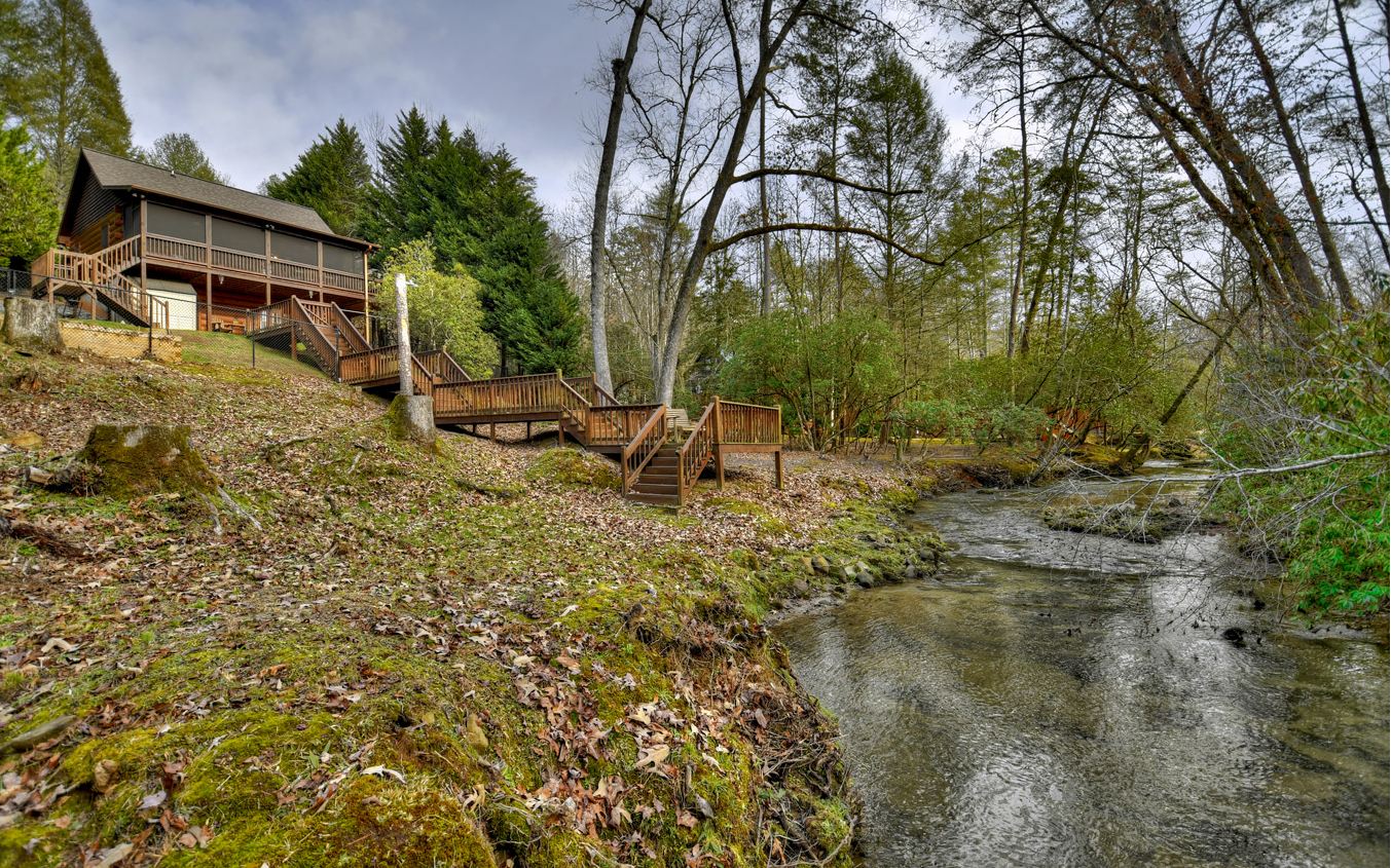 This is an amazing 175 feet of loud creek frontage property with a true log cabin. Also on the property is a fully temperature controlled art studio that was built with just as much detail as the cabin with it's own deck. A huge fenced in backyard for your fur babies to enjoy. The screened in porch is on the main level along with outdoor decks with beautiful creek views. Inside offers an open floor plan with a gas fireplace. One bedroom on main floor with large bathroom. Additional 3 rooms and bath on terrace level. Fabulous driveway and landscaped. The home has been highly maintained and is newly stained. 50 AMP breaker for RV. A must see.