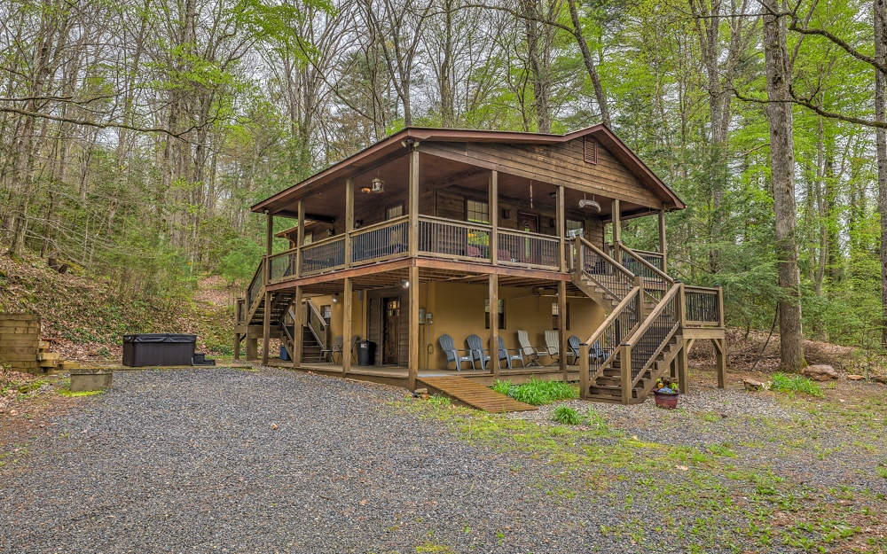Pleasantly private and bordered by hundreds of acres of National Forest and just passed Swinging Bridge over the Toccoa River access road, this cabin is an amazing location for doing what you love in the mountains. Deemed "Hemlock House" sits hillside tucked away in the trees with the soothing sounds of the creek across the road. Great space with two bedrooms up and bath with classic claw foot tub/shower. Terrace level features private primary bedroom/bath with handicap access. No worries for those who find stairs a challenge, this cabin comes with its own elevator allowing everyone to enjoy every part of this beautiful property. Outside you will find the hot tub area with fire pit and hundreds of acres to hike, bike, or drive into the Swinging Bridge area. Wonderful rental opportunity fully furnished!