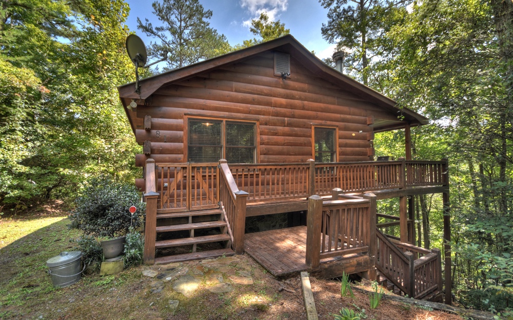 Cozy and inviting true log home in the heart of Cherry Log! This 2/1 home features a quaint great room with stone wood burning fireplace, & lots of natural light. Adjacent kitchen features plentiful cabinets & breakfast area. Two bedrooms on main share a full bathroom and laundry in closet. Amazing covered porch to take in the sights and sounds of nature. Finished basement area offers an additional great room/ living space, a perfect place to gather, watch the game or a teen hangout. Private location, just a stones throw from the Benton-McKaye hiking trail, w/ gorgeous creeks & wildlife. Conveniently located between downtown Ellijay and Blue Ridge. Offered fully furnished and turn key rental ready.