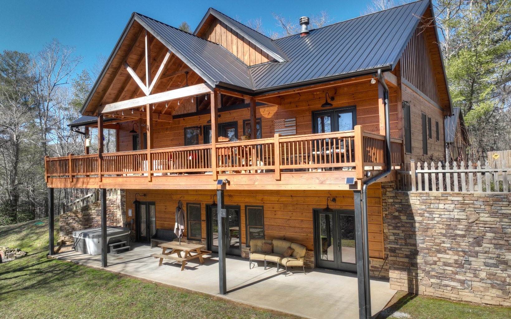 Walk in & you'll immediately fall in love with the charm & details this cabin possesses. Under 5 mi from Downtown Blue Ridge - already on a successful rental program, this one will not disappoint! Upgraded finishes, unique lighting, cathedral ceilings & amazing rustic touches all combine to keep you in awe as you walk through. Chink log interior w stone fireplace, smooth finish cabinetry paired w granite countertops & eat-in kitchen. Open great room w cathedral ceilings, distinguished hardwood floors, spilt bedroom floor plan allows both bedrooms to be Masters! Separate kitchen in terrace level open to the bonus/rec room! Tin & Wood Beam coffered ceilings & beautiful stone fireplace. Oversized deck on main level & walk out patio on terrace level. Tons of room for pets & children! Actual walking trail to small fishing lake on the property! Additional building sites available as well! 1 car garage and full home generator!