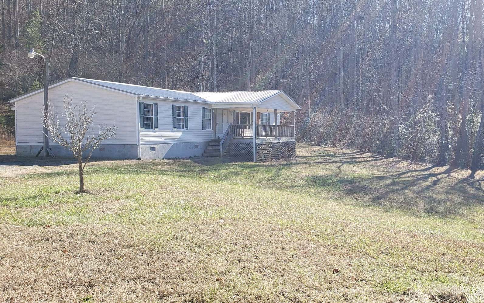 Nice gentle sloped lot with 3/2 doublewide home on permanent foundation. Front and back porches. Large yard in front and side of home. With a nice view. There is also water and power on the hill behind for an additional rental property for added income.