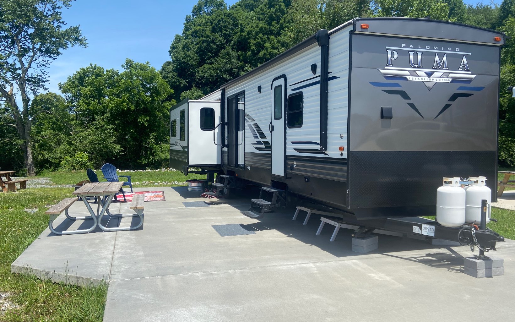 Nice RV Lot with creek frontage and a 2021 Palomino Puma Destination Trailer. Located in The Waterside Tiny Home & RV Community which offers many amenities such as a pool, hot tub, playground, lakefront clubhouse, community kitchen, a wood fired pizza oven, fire pits w/ sitting areas overlooking the stocked community lake, disc golf and a basketball goal. This area is conveniently accessed by paved roads & is close to both Lake Blue Ridge, Lake Nottely, The trout-filled Toccoa River and many other attractions that let you enjoy all that the mountains have to offer. This spacious trailer is 42' long has 4 slide outs a queen size bed, a bunkhouse and much more. (See Spec Sheet in the Documents). This property would make a great short term rental or a family base camp for exploring the North Georgia Mountains. Full time residency permitted.