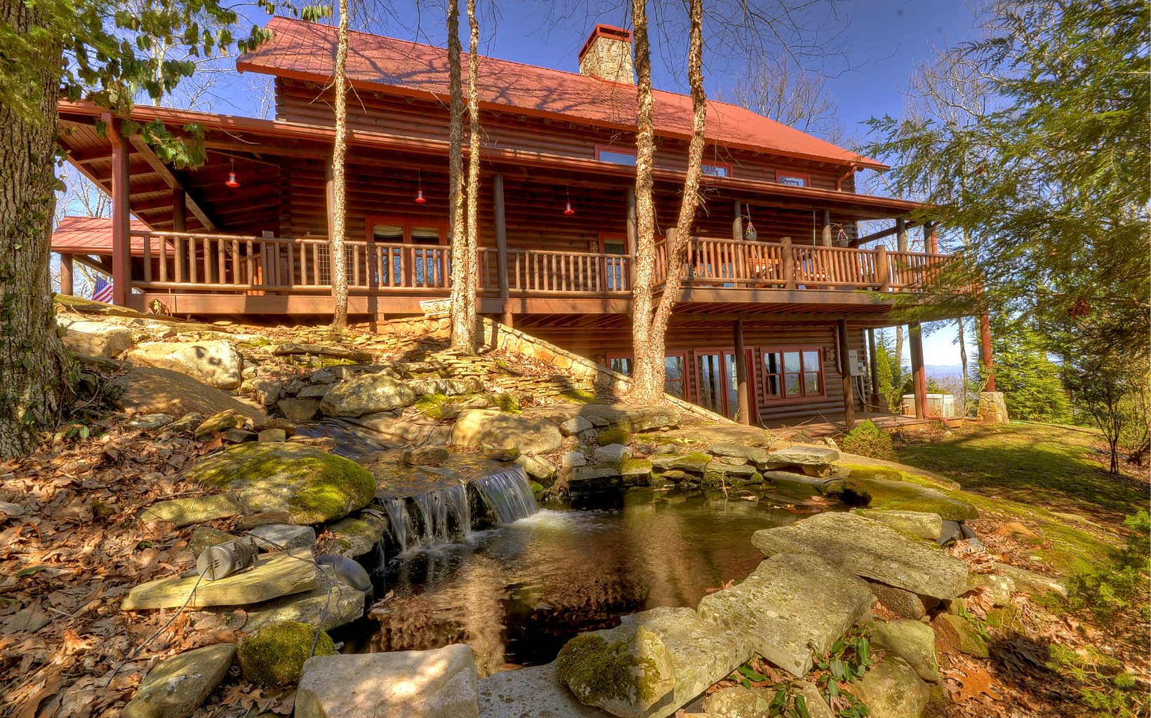 Introducing The Lodge at Fox Mtn off Big Creek.The ambiance of this magnificent mtn dream home begins as you cross the Old Covered Bridge. Pass thru the gates & begin the enchanted, winding, drive thru 23.85 ac. of one of the most scenic prop. in N GA. Park under the Porte Cochere, and enter into the cozy foyer. Beautiful lg kitchen w/upgraded appliances. Vaulted ceilings w/ex. beams . Windows & magical mtn views from every window. Double Mstr. suites on main and upper floor. Lg. Mstr bath w/clawfoot tub, double vanity sinks w/new walk in tile shower. Large living area w/ Grand wood burning stone fp & large seating area. Terrace level features 2 guest BR , guest bath & large living area w/wood burning stove. Relax on the wrap around porch & enjoy the endless long range mtn views & calming sounds of the waterfall that flows into the serene Koi pond . Lg. detached oversized garage, workshop and partially enclosed pole barn.