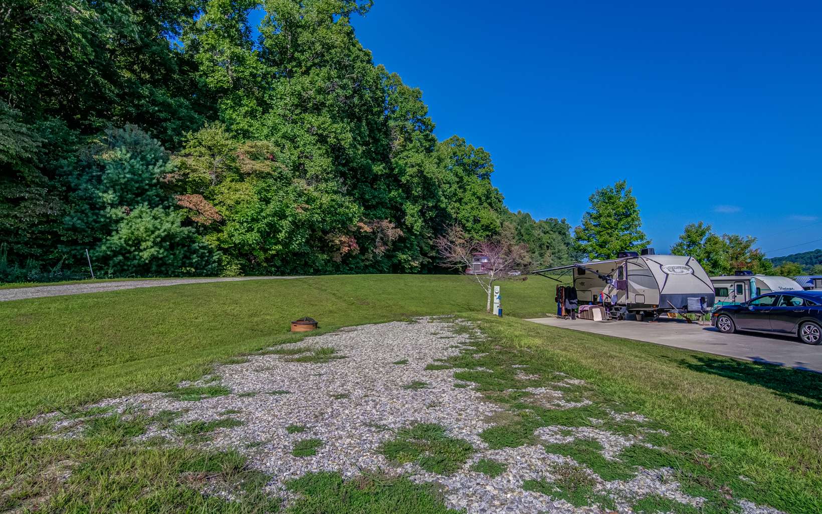 Beautiful pull-through gravel lot in the desirable Tiny Home and RV Community of Waterside at Blue Ridge, surrounded by the Chattahoochee National Forest. Amazing amenities to accommodate a magical getaway! This level lot has all hookups available, and the community features a Pool, Hot Tub, Playground, Waterfront Clubhouse, Laundry Facility, Community Kitchen with Wood Fired Pizza Oven, Fire Pits, Kayak Racks and Tubing, Fishing Dock and Stocked Community Lake, Disc Golf & Basketball. And that doesn't even include all that the stunning Blue Ridge area has to offer with extensive hiking trails, shopping, dining and outdoor recreation. Keep the lot as is, or build your dream Tiny Home; Use it for yourself, or as a short term rental. The possibilities are enless! Stop by today, this lot won't be available for long!!