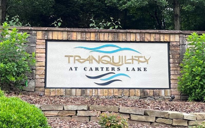 Build your lake-side dream home in Tranquility at Carters Lake! This gated community is built along Carters Lake - just 5 minutes to the boat ramp and day use/picnic area. Only 10 minutes from Ellijay and 70 miles north of Atlanta. Driveway ready, this 1.11 acre parcel is sparsely wooded on the build suite and has potential views with confirmed soil test. Rear of lot borders Harris Creek! Paved roads, gated entrance, public water and underground utilities are ready to go. Most nearby homesites are wooded and subdivided into 1 - 2 acre lots, anticipating a full development while preserving natural beauty and peaking mountain/lake views. Tranquility at Carters lake features a monitored boat storage lot for your convenience to the lake, as well as a serene community park alongside Harris Creek to include walking trails. Check uploaded documents for soil test. Call/text Listing Agent with questions or to schedule a tour with gate code.