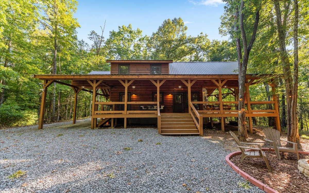Charming Storybook Cabin boasts refined rustic flair Inside & Out with warm industrial finishes…”not your cookie cutter” this spacious 2- 3BR/2 baths jewel boasts comfort and custom upgrades..soaring ceilings & tons of glass allow for a light, open interior, unique & cozy gas stove fireplace adorns large living area, stainless kitchen appliances & custom cabinetry, spacious bathrooms, warm industrial touches throughout, inviting interior with wood floors & unique touches, lovely & large loft makes perfect bedroom area or great for flex room…exercise, home office, sewing, and more …outdoor wrap around "gathering porch" & sprawling decks with hot tub and covered parking…surrounded by long range views of the mountains, fabulous fire pit and picnic area…..ultimate curb appeal, perfect for that much needed getaway cabin with great established rental history, minutes from The Toccoa River & Lake BR in quaint & quiet area...a must see and tastefully furnished for a turn key purchase!