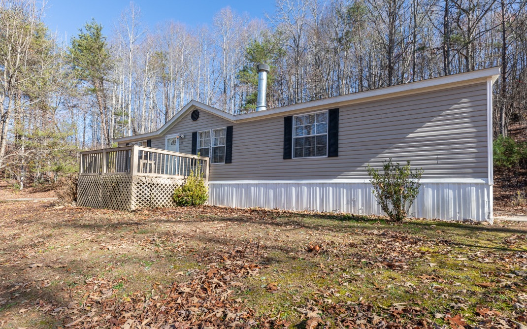 Located at the end of a dead-end road on a 1.5-acre wooded lot sits this SPACIOUS traditional home just 5 minutes east of DT Blairsville. The layout was designed for privacy with the owner’s suite on one end and two BRs and a full BA on the opposite end. Owner’s suite has a garden tub and a separate step-in shower plus double sinks. The open-concept LR/DR/Kitch has access to both the front (has stairs) and back decks (has ramp). Kitchen island includes a breakfast bar, double sink, & DW. All appliances stay. Loads of kitchen storage including a walk-in pantry! LR has wood-burning fireplace for cool evenings. Store your lawn equipment in the nearby storage shed. With gorgeous seasonal views, this home was built on a full concrete slab for stability. All electric and no propane! Homeownership is possible with this affordable, well-cared-for home in the mountains!