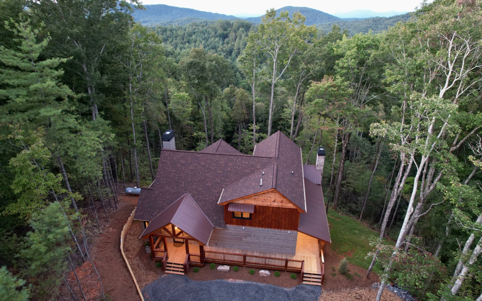 HUGE PRICE REDUCTION!!Investors take note! Stunning New Construction w/ panoramic mountain views and so much wow factor located just minutes from Downtown Blue Ridge! This 3BR/3.5 bath, 3,385 sq ft modern rustic home offers total privacy, 3 fireplaces, a master on all 3 levels, high end finishes throughout & is located in one of the most sought after areas surrounded by USFS. Walk in the door to soaring cathedral ceilings & a wall of windows showcasing the pristine mtn views! The kitchen features an open concept w/ top of the line appliances, butlers pantry & an oversized island next to the dining area. The huge living room w/ floor to ceiling stacked stone fireplace provides plenty of room for guests! Large master on main w/ beautiful bathroom and large closet. Go upstairs to an oversized master w/ private porch, full bath & an open loft area perfect for a home office or additional sleeping space. Meander downstairs to the terrace level featuring a huge game room w/ wet bar, separate living area w/ stacked stone fireplace and additional master bedroom. Wrap around porch w/ outdoor fireplace is the perfect spot the take in the beautiful scenery and to entertain guests! No detail has been overlooked and you have to see this one to fully appreciate all that it has to offer. Whether you are looking for an optimal STR or the perfect family getaway, this is one you can't afford to miss! Additional acreage available for increased privacy or option to build family compound.