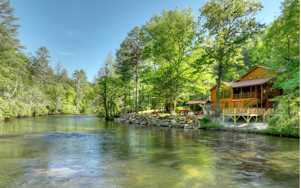 EXCEPTIONALLY BROAD "UPPER" TOCCOA RIVER FRONTAGE (Water Level NOT controlled by TVA) only 7 mi from Blue Ridge off Aska.(Rarely Available Location. Peaceful Rhythms of this "White Water" River is what Dreams are Made of. "Park-Like" Shoreline reinforced in 2021 w/Huge Boulders, 16X16 Shoreline Deck,"Rock Pavilion"(Swing) & Picnic Patio. Home BROUGHT DOWN TO THE STUD & Remodeled in 2007. (3630 sq ft) Main House (2 HVAC Systems) PLUS Separate 1152 sq ft Studio/Workshop. D-Log Sided & Rock Foundation. All Wood Interior. Massive Kitchen w/CHERRY Cabinets, Granite Countertops, Gas Cooktop, Double Wall Ovens, Brick Floor, Skylights & Separate BUTLER'S PANTRY w/Wet Bar. Huge Rock Fireplace & Real "LOG" Ceiling Beams in Living Rm."River Room" offers Floor-to-Ceilings & Gable Glass for Amazing River Views (Corner Stone Fireplace). Main Level Master Suite to Covered Porch Overlooking the River (Staircase to Shoreline). Enormous Ceramic Tile Shower & Granite Top/Cherry Vanity (Jetted Corner Tub & Big Closets). Formal Dining Area & Guest Half Bath w/Laundry (Granite & Cherry) on Main. LOG Staircase leads to Upper Level Lounge outside (2) Guest Bdrms. One features transom windows & Second offers a Sitting Area.(Double Door CEDAR Closet).Separate 2-Story Studio/Workshop connected to Main House by Elevated Staircase (Wood Flrs & Wainscoting) w/Separate Entry & HVAC. HUGE Basement w/Pull Under Garage (Concrete Floor)
