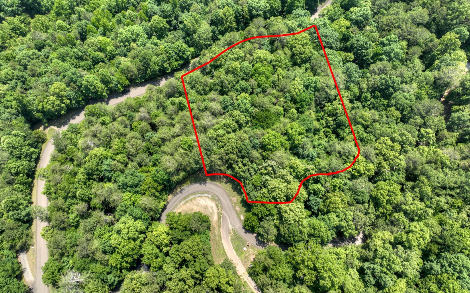 Beautiful 3.08 acre lot in the upscale gated community of Mountain Creek Hollow. This wooded lot is ready to build your dream home with road frontage on upper and lower sides. This subdivision is nestled in the foothills of the North Georgia Mountains and includes amenities such as a trout pond, butterfly garden, waterfalls, hiking trails, and a covered bridge with a neighborhood picnic area beside the noisy Fausett Creek, which runs throughout this private community. There are approximately 275 acres of rolling scenic and wooded mountains and streams throughout the neighborhood. It is close to vineyards, as well as Ellijay restaurants, movie theater, and shopping. This lot would be the perfect lot to build your full time home in a peaceful area you are sure to fall in love with!