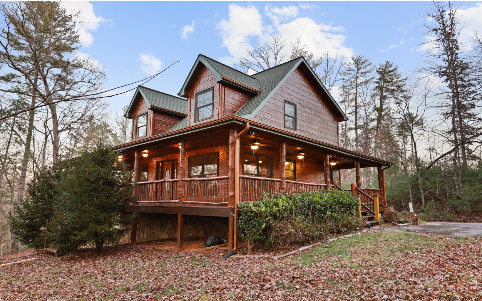 SENSATIONAL 3BR/3BA Hand Hewn Chink Cabin located in desirable Blue Ridge Ga.This 2 story cabin has an expansive covered wraparound porch and rests on 1.57 acres of beautiful unrestricted private land. A rustic beauty, adorned with cathedral ceilings, tongue and groove walls, ceilings and floors that showcases an open concept eat in kitchen with granite countertops, tile backsplash, and a center island. In the great room, enjoy breathtaking views and appreciate the expansive floor to ceiling stone fireplace that will take the chill out of the crisp cool mountain air. The roomy master suite on the main floor includes a newly remodeled full bath with a double vanity, walk in shower and jetted soak tub. A spectacular Mountain Laurel Staircase leads to the 2nd floor bedroom,loft and private bath. Downstairs is a finished basement complete with bedroom and full bath. The door leads out to a convenient one stall garage. Other features include a fire pit, level terrain, storage shed and a favorable circular driveway.