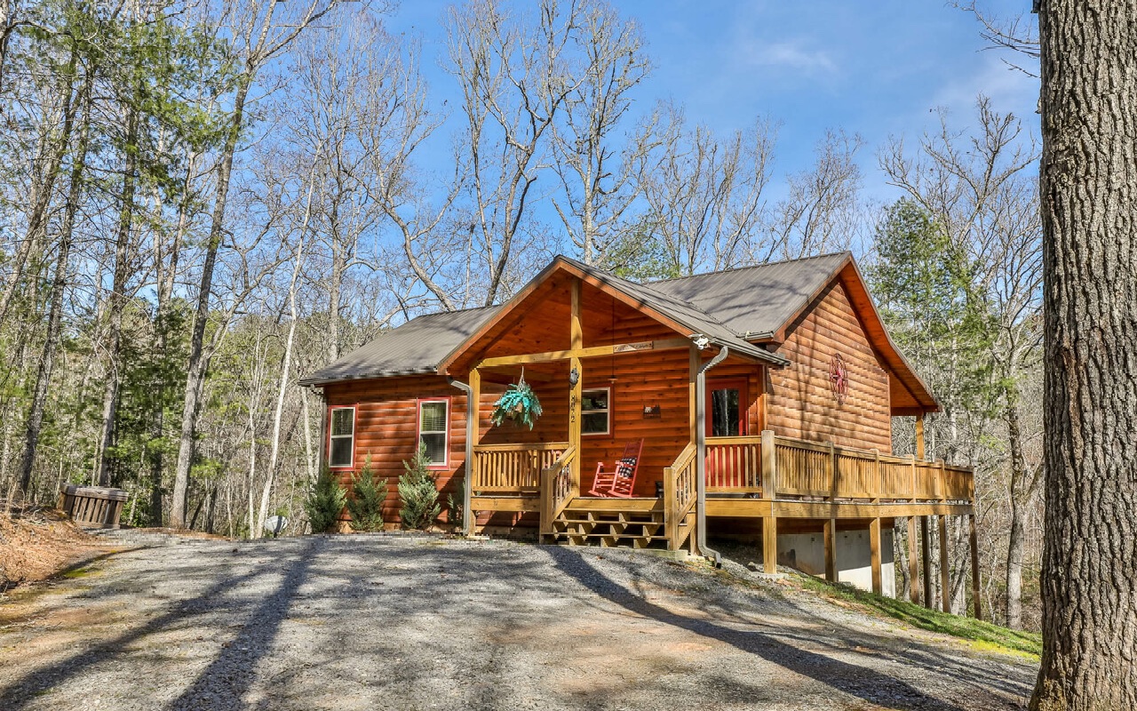Looking for a cozy retreat in the heart of nature? Look no further than this like new 2 bedroom, 2 bath cabin located in Mineral Bluff. Built in 2018, this charming cabin features log siding exterior w/ metal roof & a front porch wrapping around to the huge rear deck perfect for entertaining w/ hot tub to soak in the serenity of the woods. Inside find a great room with vaulted tongue & groove ceilings & stone fireplace. Kitchen has custom cabinets, stainless steel appliances & granite counters. Master on main w/ ensuite bath and another large main floor bedroom w/ hallway bath. The light & bright full-size unfinished basement w/ plumbed 3rd bath and exterior French doors offers plenty of opportunity to expand or keep as additional recreation room! Enjoy nearly 2 acres of land for breathing room w/ firepit to relax and roast marshmallows. Don’t miss your chance to make this furnished, turn-key rental cabin your own!