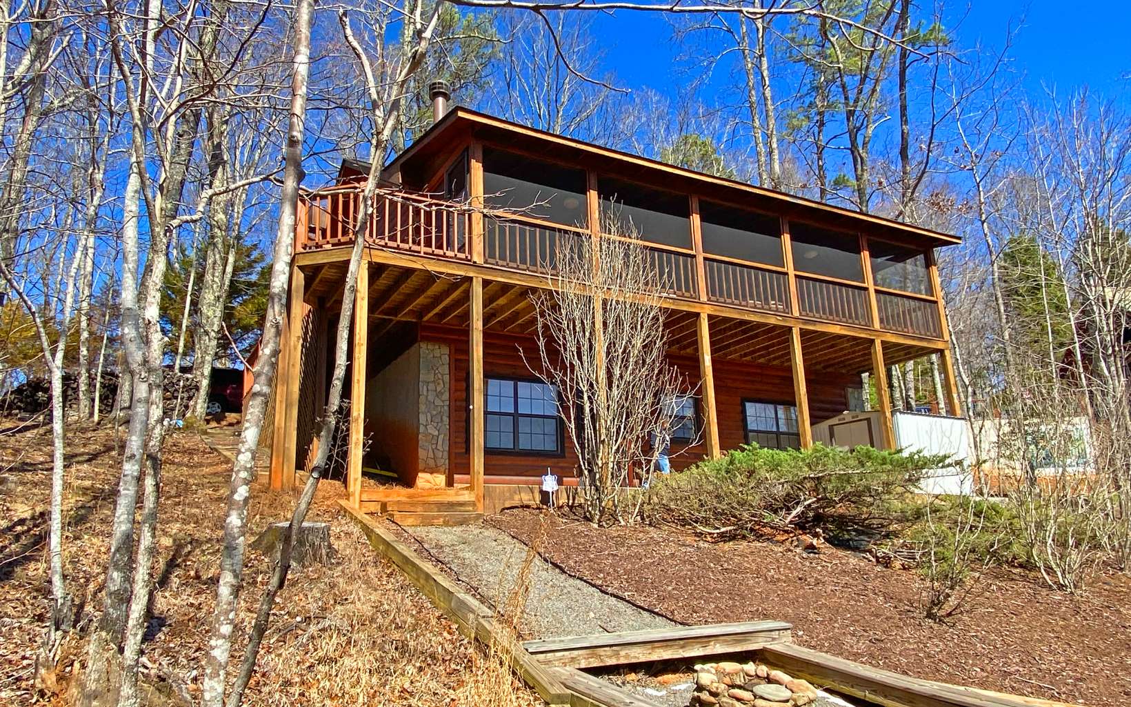 This 3BR, 2BA solid log cabin has 1872 sq. ft., is on .95 AC with YEAR-ROUND, LONG-RANGE LAYERED MOUNTAIN VIEWS! The cabin is offered furnished and borders USFS which offers a hike to access to Lake Blue Ridge. There is a lovely screened-in back deck to take in the fantastic view and a fire pit area for evening camp fires. Great room upstairs and large recreation, TV room downstairs. On one of the most scenic ridges in the area, this cabin is perfect for full-time living, a rental program, or simply a vacation or weekend home. Located only 15 minutes from thriving Blue Ridge. All-paved road access! Hiking out your front door, a 15-minute drive to Toccoa River trout fishing spot, and only a 30-minute drive to Ocoee Whitewater Rafting, this cabin will not last long. STR allowed.