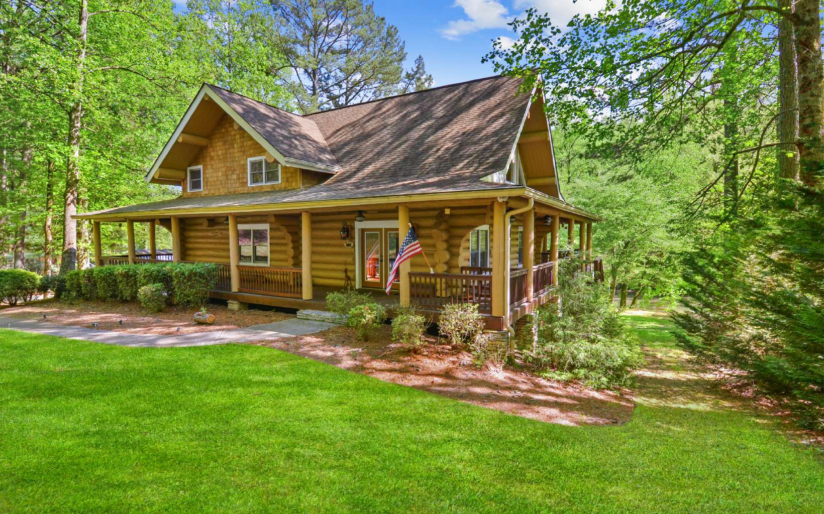 Welcome to this stunning true Canadian log cabin nestled on the Coosawattee River—a rare find with a flat lot on this highly desired river. Prepare to be captivated as you enjoy the sights and sounds of the rapids from the wrap-around porch or relax on the spacious deck by the water's edge. Every detail in this intricately decorated 5-bedroom, 4-bathroom home has been carefully considered, and it is being sold mostly furnished for your convenience. Step inside and be greeted by soaring ceilings, a two-story wall of windows, and a magnificent stacked stone fireplace. The real hardwood floors, granite countertops, and custom cream cabinetry in the well-appointed kitchen add a touch of elegance. Equipped with stainless steel appliances and a wine cooler, this kitchen is a dream for any culinary enthusiast. The large master bedroom on the main floor boasts a walk-in closet, an in-shower tower, a tiled shower, and a beautiful tile floor. Upstairs, you'll discover an additional master suite, two guest rooms, and two bathrooms. The second master suite features hardwood floors, high ceilings, a spacious master bathroom with his and hers sinks, tiled floors, a Jacuzzi tub, and a tiled shower. The finished terrace level offers a mini bar for entertaining, a pool table, a movie room, a fifth bedroom, and a fourth bathroom. For added convenience, there are laundry hookups on both the main and terrace levels. Recent improvements include an updated shower upstairs, new paint throughout, st