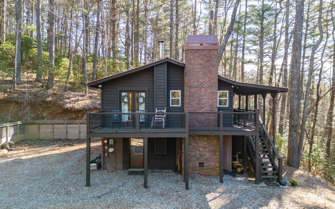 This home is such a GEM and has many updates made in the past 2 years. The rustic style cabin offers 2 stories of living space that includes a recently-finished full-daylight basement that features a den w/ a wood-burning stove, a full-light exterior door to let in the sun, exposed beams, a BR, full BA, & laundry rm w/ cabs. The main floor features a LR w/ brick vented FP, kitchen w/ S/S apps, separate DR, primary BR w/ a pocket door & French doors that access the deck, & a sprawling en suite BA that includes a shower/tub, 2 separate vanities, & a walk-in closet. Modern farmhouse finishes: lighting, shiplap, color palette, dark-stained wood, & LPV flooring throughout. This home has been lovingly restored and is full of character. Seasonal long-range mountain views, huge parking area, newer decking w/ iron rod railing, & covered deck entrance w/ wraparound deck. Barn door doesn't stay.