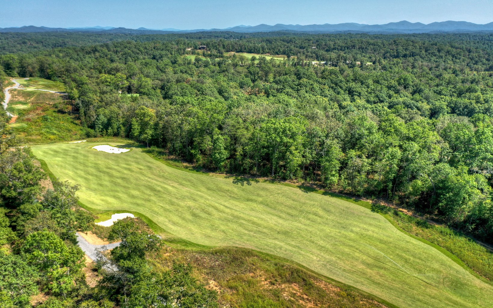 Be home on the fairway of Old Toccoa Farm, the most illustrious golf course in North Georgia. Lot 142 is one of the most premier lots in this Golf Digest award nominated community. Enjoy beautiful brunches and exclusive wine dinners for members only at the newly built clubhouse and restaurant, or play a round of golf alongside the Toccoa River. This homesite offers 4,000 feet of deeded river access, all underground utilities, high speed internet, paved roads, and 24 hour guarded gate. With custom home plans already available—saving months of planning—this lot is ready to build your dream home in the most well designed lifestyle communities in Blue Ridge. We have also designed a pet-friendly side yard for every member of your family! This is the hole-in-one you’ve been dreaming about. For video, please text Listing Agent.