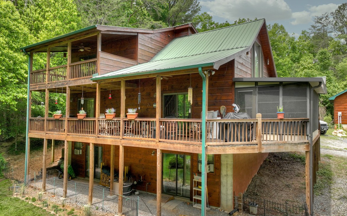Leave the hustle & bustle behind to escape to your retreat in the mountains… Just minutes from downtown Blue Ridge, and just “up the hill” from the Toccoa River, you’ll enjoy amenities galore at your fingertips yet feel completely tucked away in the heart of the mountains. This wood retreat offers many possibilities as your full time forever home, vacation home, or even a rental investment to produce income. This cabin offers plenty of space outdoors for room to roam with gentle terrain, three outbuildings/workshops, carport, plenty of decking to soak in the great outdoors and fenced areas for those four-legged loved ones. Great for entertaining both inside & out, this beauty offers a fantastic open floor plan and sleeping quarters on each level. Other highlights incl. soaring cathedral ceiling in the living room, sauna, full finished basement, laundry on the main, sunroom, and more. It’s just missing one thing… YOU!