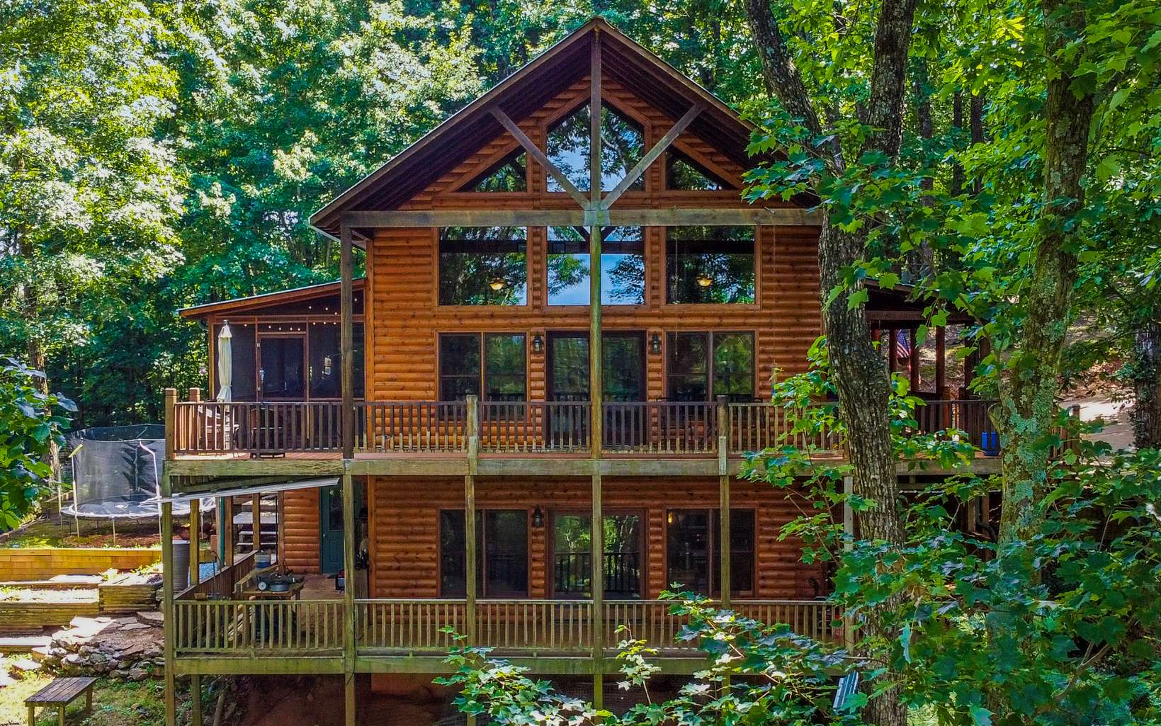 Charming Cozy Cabin with STUNNING North GA Mtn views, gently situated on 2.37 private acres of unrestricted land only 8 miles to DT Ellijay! This one of a kind cabin features 4 bed/ 3 master bath with a jacuzzi tub, tile shower and large garden tub, 2 living rooms, 2 full kitchens, 2 gas log fireplaces, an office area, roaring ceilings with plentiful large glass windows for a very open concept feel, real hardwood floors, granite countertops, luxurious tile bathroom floors & shower, master on main with walk in closet, chef's kitchen with custom cabinetry, a large pantry & stainless steel appliances! The fabulous fully finished basement features a 2nd living room and full kitchen that is perfect for guests, a big group or family to use. Would also make a great movie room/game room/apartment! Wonder outside to relax on the wrap around porches that are on each level, a screened in porch area, firepit area, fenced in yard area for dogs, large garden shed/utility closet perfect for storage and more. No to mention home wired with SONOS sound speakers for the best sounds when listing/watching TV. $70-80k rental projection from local Vacation Rental company! HVAC serviced in Sept 2020. Would make a great vacation rental- perfect for full time, much needed getaway or smart investment for a retreat. No details were left out on this beauty, come view today!