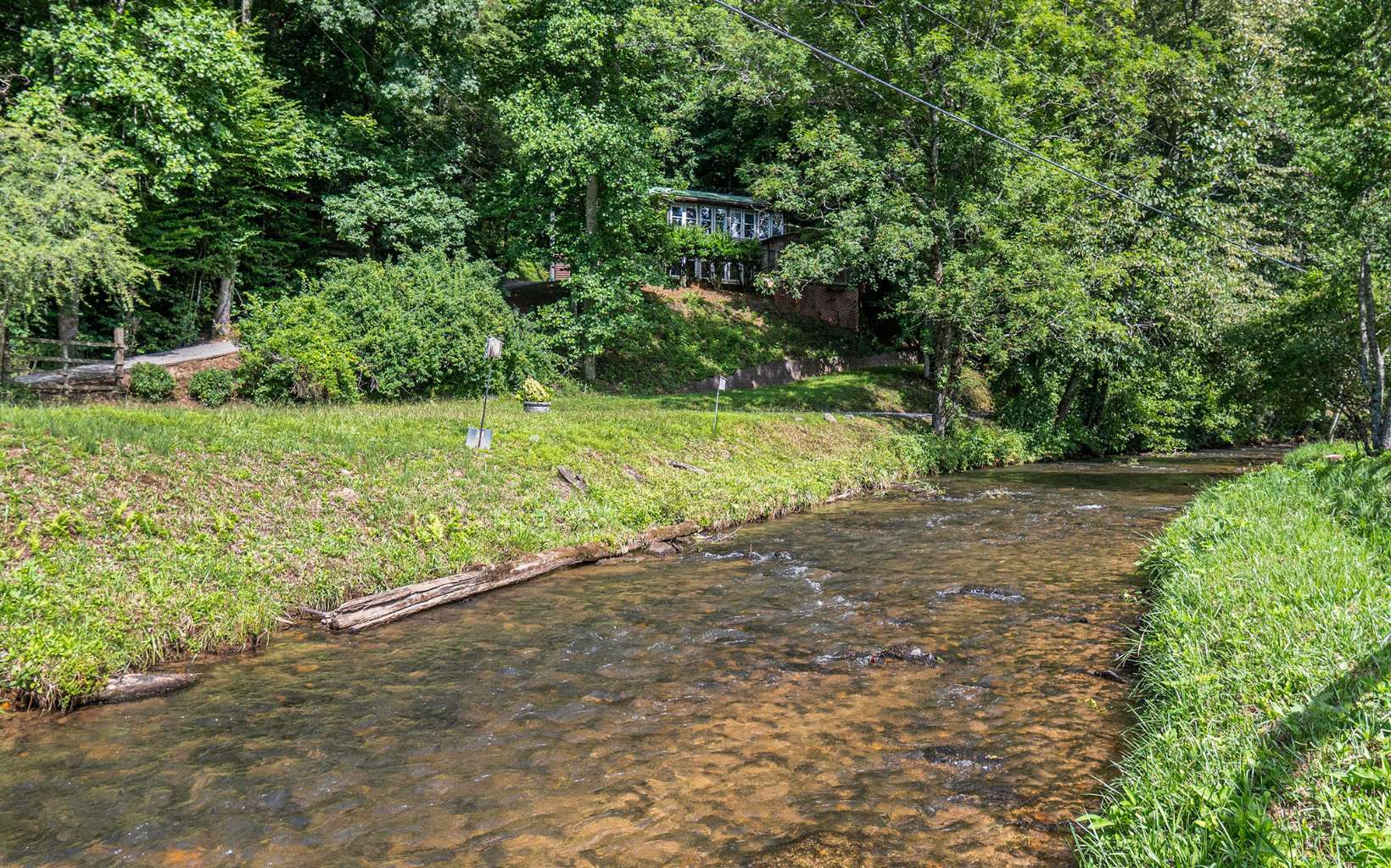 Appropriately named Hidden Valley-This cozy cabin, lovingly called "Rabbit Hill", is nestled in the valley, perched perfectly above Little Mountaintown Creek. Enjoy the sounds and life of living on the Water. Yes-CREEK FRONTAGE! You own to the center of it! GO FISHING anytime or Sit Back-Relax-Take a nap listening from the breezy Screened In Porch. THIS HOME HAS CHARACTER GALORE with many unique features- starting with a little cabin style well house with extra storage for your toys-a rustic 2 stall parking shed- a green house addition-an upstairs deck off the sunroom overlooking the green fields, meandering fences,the Creek & Seasonal Mountain View-a wood burning fireplace for chilly mountain nights and mature hardwoods providing shade in the summer time. It is like living in a bird's nest tucked away with an eagle's eye view of the valley. Come Experience The Good Life!