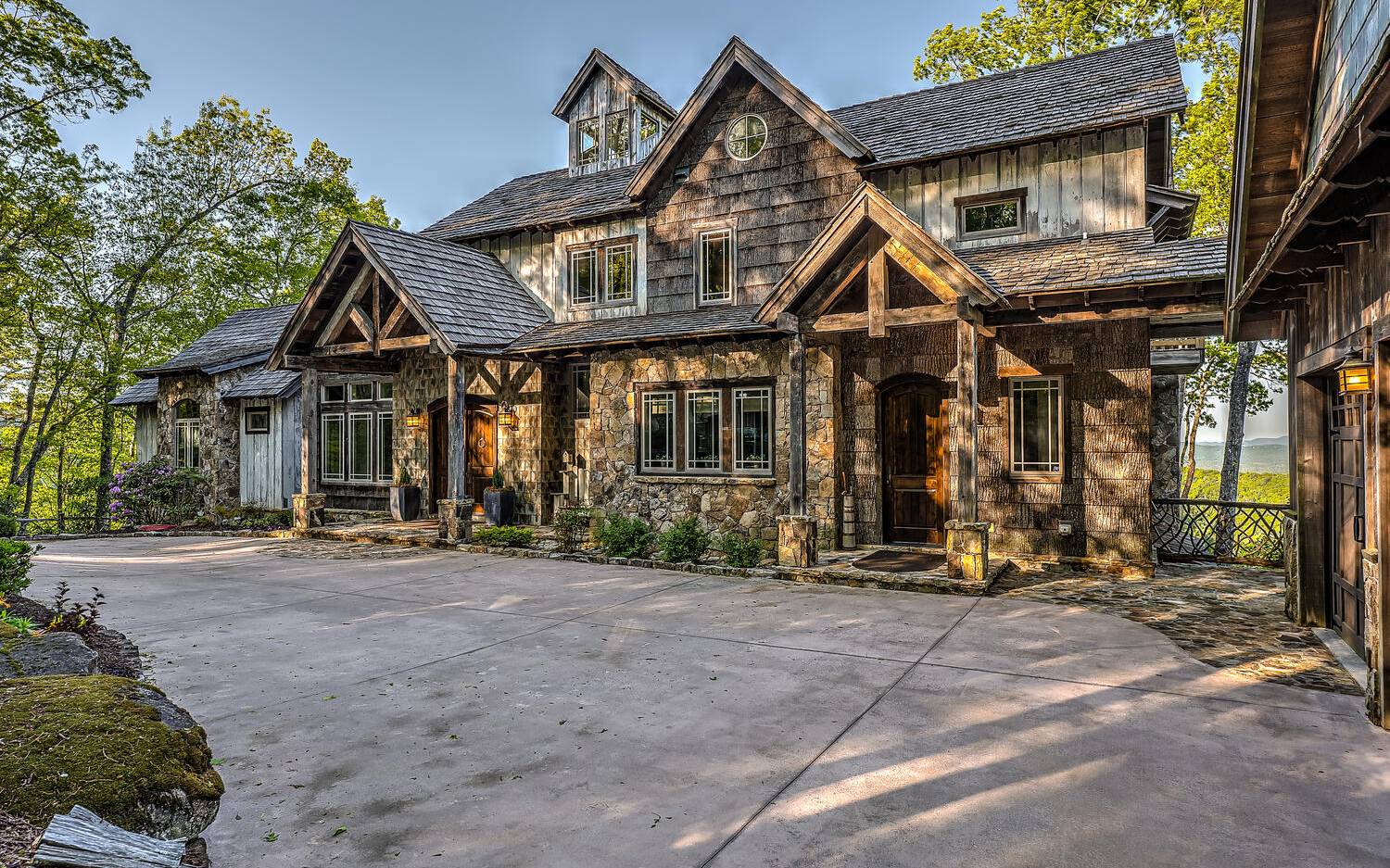 THIS ONE OF A KIND RUSTIC home on private 2.14 acre lot w/magnificent layered MOUNTAIN VIEWS is extraordinary in every detail & design w/natural elements sourced carefully & painstakingly to make it unique. This open floor plan boasts timber frame accents, Tennessee fieldstone fireplace, wide-plank wood flooring & wall of windows w/25' cathedral ceiling to capture the VIEW. Owners suite on main level complete w/TWO full separate owner's baths, custom tiled, walk-in closets and fireplace; gourmet kitchen w/custom cabinetry and high-end appliances, butlers pantry & laundry on main level, screened in porch w/outdoor fireplace and dining area, upper level w/two bedrooms each w/private bath, separate study/library, finished terrace level w/two guest suites, recreation room, sauna, ELEVATOR for access to each level & ADA compliant bathroom on second floor, detached 3 car garage, whole house generator, multiple storage rooms,