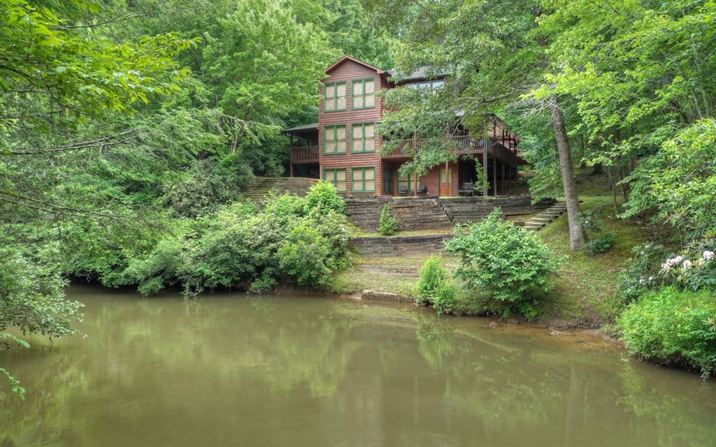 *FIGHTINGTOWN CREEK RETREAT* Upon entering the meticulously maintained main cabin, you are greeted by an open floor plan decorated with floor to ceiling windows for a direct sight line to the deepest parts of Fightingtown Creek. Kitchen boasts detailed custom cabinetry, industrial stainless steel appliances, and beautiful granite countertops. On the main level you will also find a spacious living area and guest bedroom/bath. Make your way upstairs to find an additional bedroom + en-suite alongside the spacious primary bedroom providing a walk-in closet and en-suite. The basement provides plenty of space for entertaining + an additional full bath and direct access to the fire pit overlooking the creek. Heated & cooled garage offers a workshop, studio and half bath on the main level + a 2 bed/1 bath apartment above. Perfect for part time or full timing living just minutes from downtown Blue Ridge and downtown McCaysville!!! Enjoy tubing, trout fishing or waterfront relaxation!