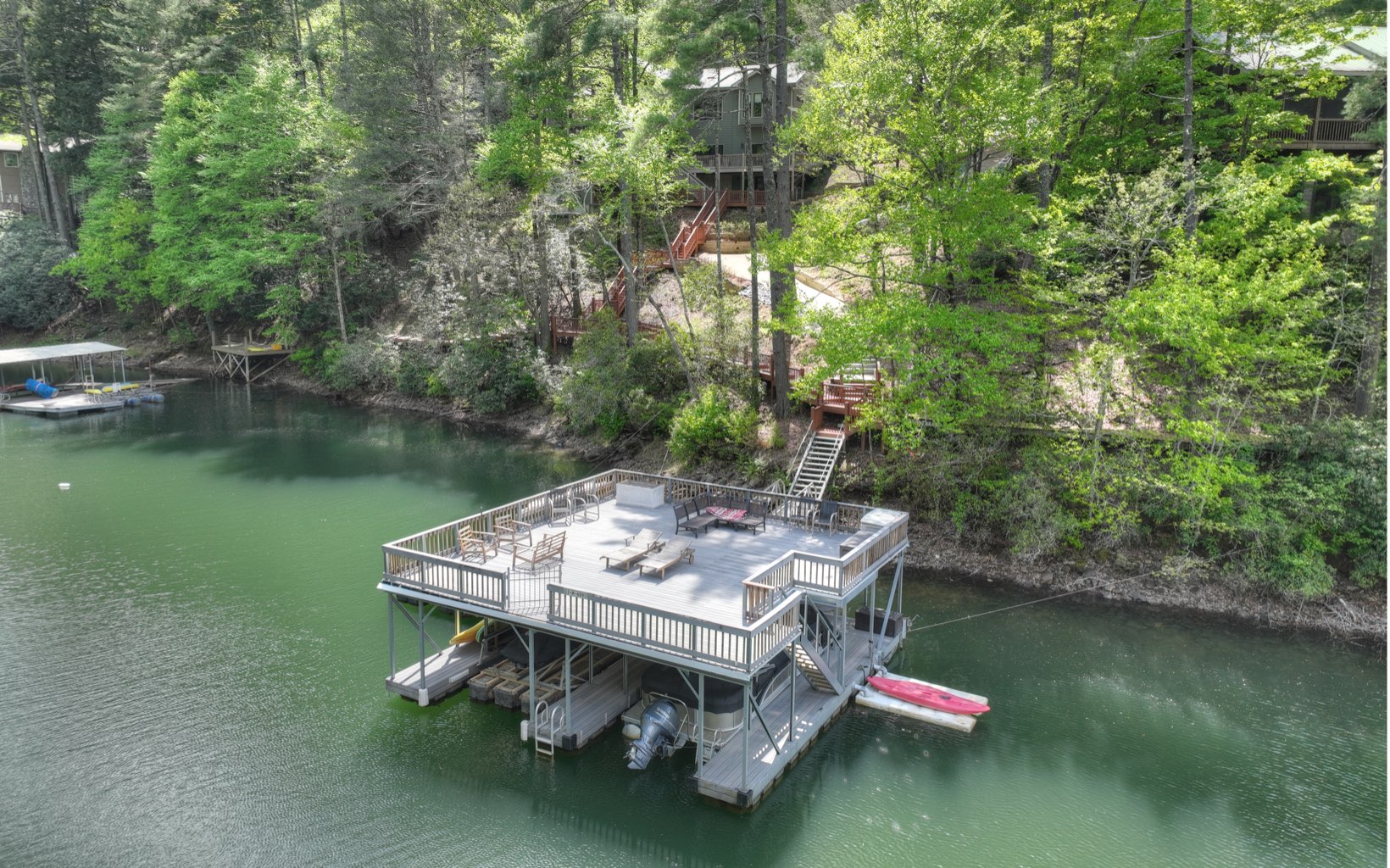 Incredible Lake Blue Ridge home w/ year round deep water, private cove, waterfall views, paved access, only 10 minutes from Blue Ridge! 4 bed/3.5 baths, 3 living areas, huge kitchen & amazing outdoor living space to take in the views of the lake & the sounds of the waterfall. Large double decker, 2 slip dock w/ 177' of lake frontage. Private concrete path or steps through the towering hemlocks & mtn laurel to the lake. Upscale primary suite w/ spacious sitting area, fireplace, lake views, HUGE closet, laundry, & spa like bathroom. Kitchen offers a walk in pantry, island, dining area all open to the expansive great room w/ soaring ceilings, oversized stone fireplace & large windows overlooking the lake. Terrace level offers 2 more gathering areas, a bunk room, 2beds/2baths, an office & 2nd laundry. 2 garages (a 2 car & the other a 3 car), & long private driveway. Located in the Aska Adventure Area!