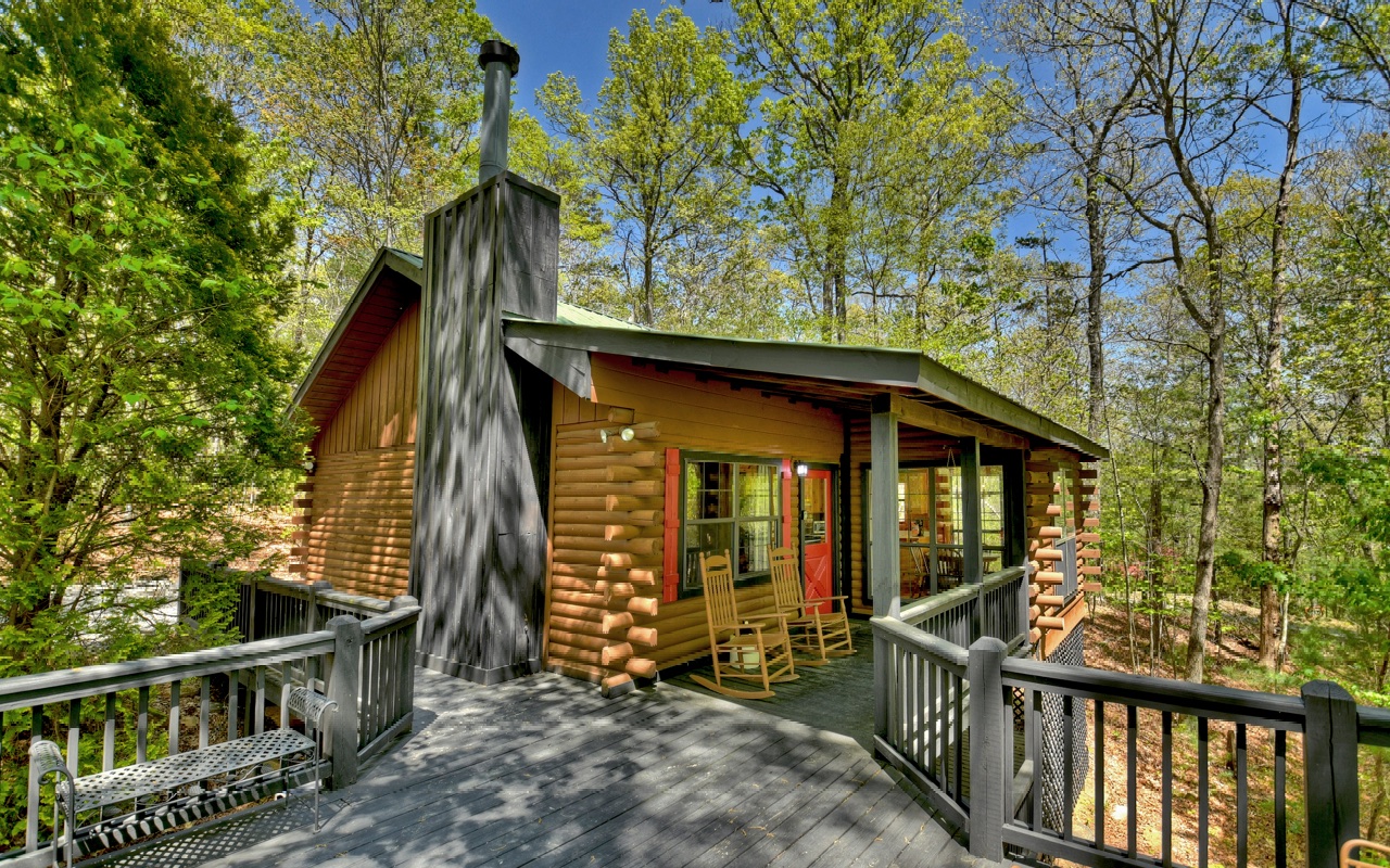 Nestled in the sought-after Cherry Lake community, this short-term rental property boasts a remarkable gross of 46k in 2022. You'll be enamored with its serene ambiance, showcasing an ideal setting to indulge in the mountains’ tranquility—just a short 5-mile drive from Downtown Blue Ridge. The cabin has been meticulously maintained, ready for you to delight in the warmth of the outdoors without sacrificing on luxury. The fully equipped kitchen, seamlessly paired with the open dining area, provides picturesque views of the surrounding greens and hues. Wall to wall windows floods natural light in the space, creating a warm and inviting atmosphere. Relaxing in the cozy living room, the eye-catching cathedral ceilings adorned with beautiful wood beam accents in both bedrooms add a touch of luxe without sacrificing on comfort. The kids will love the sleeping loft, overlooking the living room while the parents cozy up to the stunning stone fireplace. Entertaining guests is a breeze with an enormous deck space for recreational activities, including a bubbling hot tub to melt your worries away. To keep you wanting to come back, games, and other fun activities are included, perfect for family bonding. The cabin features upscale furnishing and décor, providing an inviting and luxurious ambiance. The owner/manager is determined to make your investment a continued success as well!