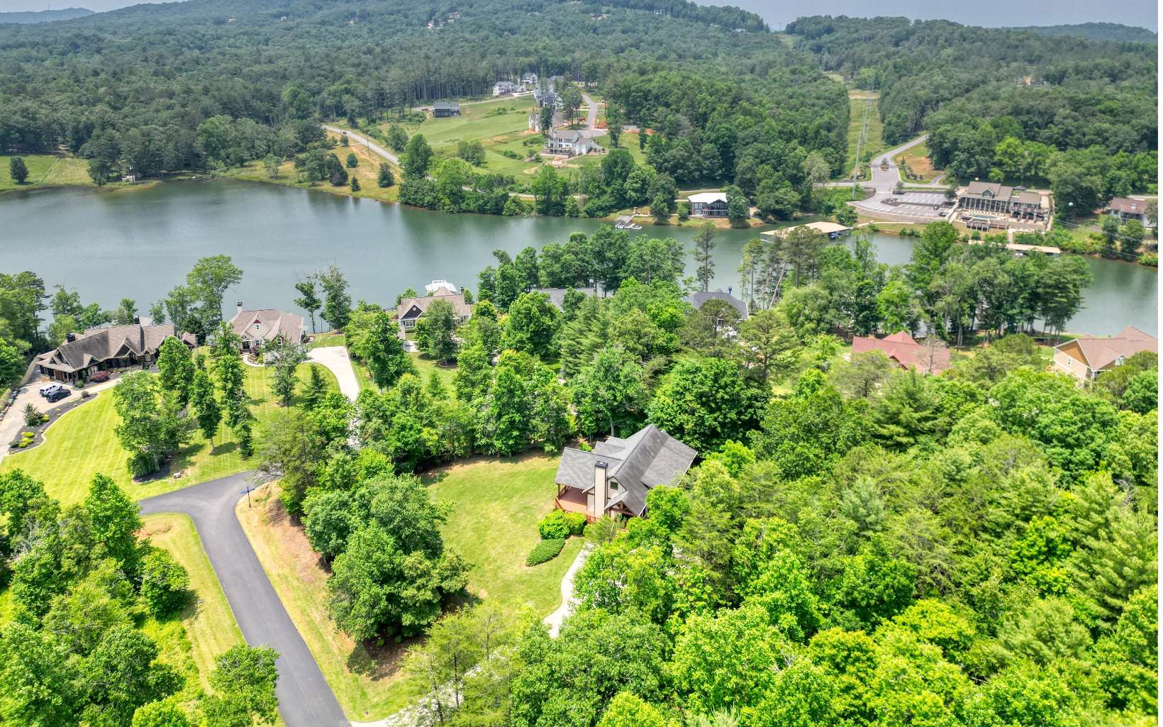 Bring your boat & start your new adventure in this tremendous 4 BR, 3 bath custom home in Tallulah Landing gated comm. w/ private marina/boat ramp & pavilion. BIG corner lot on .93 acres w/ Hardiplank concrete siding & seasonal views of Lake Nottely (across the street) & surrounding mountains. Huge great room w/ vaulted wood ceilings & stacked stone gas fireplace. Main level has oak floors, gas range & heated tile floor in main bath. Primary BR & 2nd BR on main & 2 BR's on terrace level. The walk-out basement has a spacious rec/living room with a custom wet bar including beverage wine & coolers, kegerator & microwave. Smart home system for sound/ thermostats/select lights/security system. Garage is 30X24 w/ 100 amp service for additional living space. Located less than 2 miles from downtown Blairsville & Butternut Golf course it's has everything you'll need for vacation or full time living. Must see!