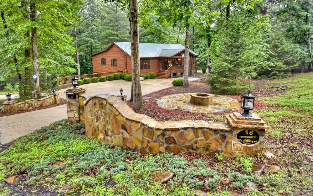 EMPHASIS ON LIVING with this 3BR/3BA Ranch Style Cabin. A definite "WOW" with a beautiful rock waterfall water feature and outdoor firepit area. Cabin includes 2 lots (1.39 acres), being sold mostly FURNISHED; featuring a split bedroom floor plan with vaulted wood ceilings, center island in kitchen, pantry, huge master suite w/sitting area, rocking chair front porch, lovely back porch & screened porch, 4 fireplaces (1 gas logs & 3 electric). Full finished basement with recessed ceilings, large family and media room w/custom built-in cabinetry, additional room for home office, hobbies or exercise. 2 car basement garage, carport, tile patio & concrete driveway. (High speed internet) This home is in great condition! Located in a popular mountain community with amenities galore! Very easy access, close to gated entrance, all paved roads. Perfect for full time or vacation home.