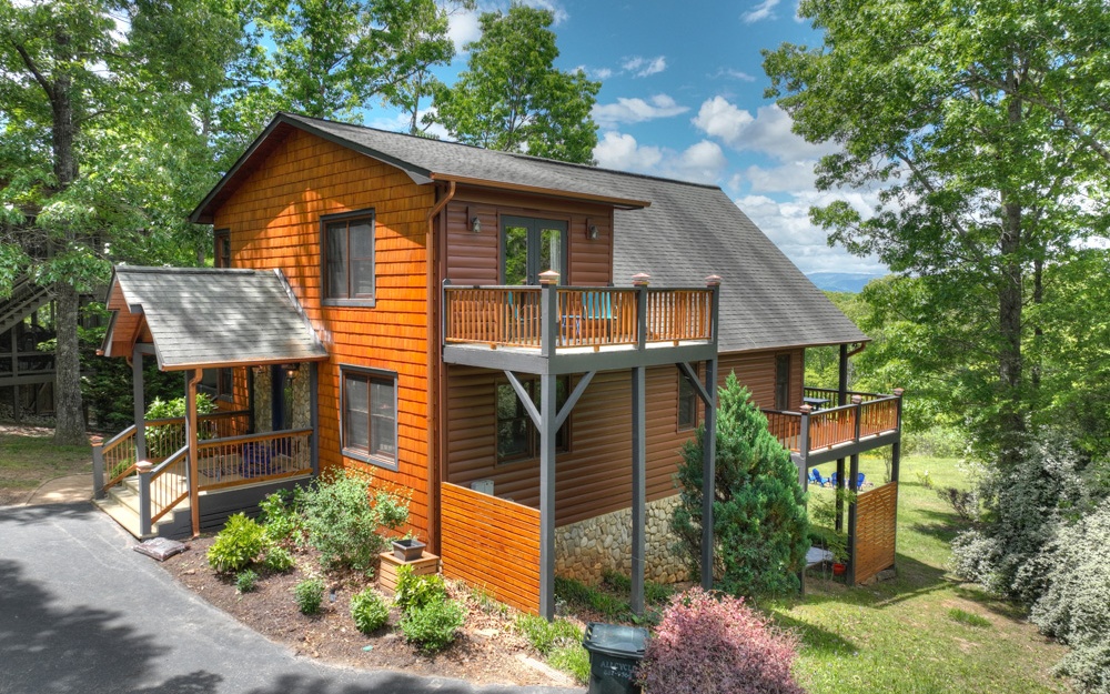 Pack your bags… it's time to go up, up, & away to the beautiful North Georgia Mountains! Whether you’re considering full-time living, your personal mountain getaway, or looking to add to your rental investment portfolio, this modern rustic cabin is the dream! Accessed via all paved roads, this charming retreat is convenient to all the tri-state area has to offer - daily needs, entertainment, and more. Immaculately maintained both inside and out, this dreamer boasts three levels of living, the open floor plan you’ve been looking for with soaring ceilings & plentiful natural light that unite the kitchen dining and living area complete with stone fireplace, fantastic party porch with fireplace, all wood interior, custom tile showers, upgrades galore, new hvac, updated kitchen, gentle back yard, lovely landscaping, firepit and, of course, a great mountain view! What are you waiting for? Your mountain paradise awaits…