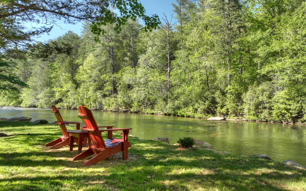 Become One with Nature & experience ENDLESS ADVENTURE in your own Front Yard. Perched on the Banks of the UPPER TOCCOA River ABOVE Lake Blue Ridge w/Consistent Water Levels & No Flood Insurance. Successful RIVERFRONT VACATION RENTAL w/a "Park-Like" Shoreline reinforced in 2021 w/Massive Boulders offering a 16X16 Shoreline Deck,"Rock Pavilion"(Swing) & Picnic Patio. The Main Lodge was BROUGHT DOWN TO THE STUDS & Thoughtfully Re-Designed in 2007. The DETACHED (1152 sq ft) Studio (Workshop/Game Rm) is connected by Elevated Walkway to Lodge. Log Sided w/an All Wood Interior & Elegantly Furnished. Massive Kitchen w/CHERRY Cabinets, Granite Countertops,Gas Cooktop, DOUBLE Wall Ovens, BRICK Floor, Skylights & Separate BUTLER'S PANTRY w/Wet Bar. "SIGNATURE" Rock Fireplace & Real "LOG" Beams adorn the Living Rm. "River Bonus Room" offers Floor-to-Ceilings Windows overlooking the Rapids & Gable Fixed Glass for Amazing Light along w/an Impressive Corner Stone Fireplace. Main Level Master Suite to Covered Porch leads to a Staircase to the Shoreline. Main Level OFFICE. Master Bath features an Enormous Tile Shower & Granite Top/Cherry Vanity (Jetted Corner Tub & Big Walk in Closets). Formal Dining Area & Guest Half Bath w/Laundry (Granite & Cherry) finish the Main. LOG Staircase leads to Upper Level Guest Lounge (Sleeping Quarters) outside Spacious Guest Bdrms featuring Transom Windows, Seating Areas & Large Closets. Peaceful Rhythms from this BROAD RIVER FRONTAGE...will soothe your Soul.