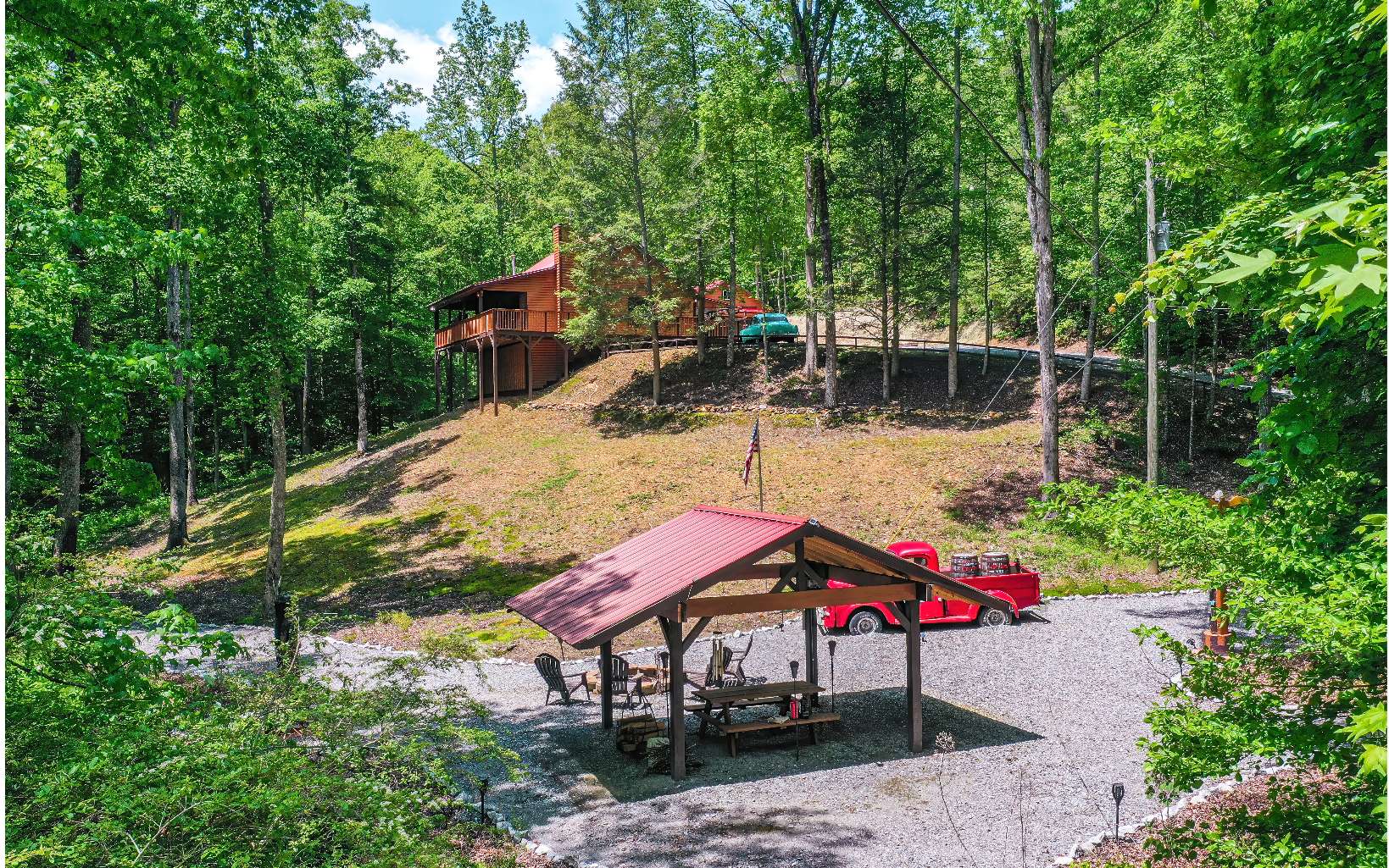 This incredible 2BR, 1BA quintessential rustic log-sided cabin home has 1,408 sq. ft. This rare gem resides on a tranquil 4.91AC w/ approx 1000 ft of noisy chattering stream frontage along 2 streams that converge on the property just below the front porch. It’s a very unique opportunity to own both sides of the stream in a very private setting where you don’t see a single neighbor yet so close to the towns of Ellijay & Blueridge. The gravel road is easy. This property was on a successful short-term rental program, netting $35K in 2020, $25K in 2021, & $10K in the 1st quarter of 2022 when it was removed from rental & is being sold completely turn-key. The interior is all tongue & groove wood. The bedrooms are very spacious. The master is on the main, & the kitchen was completely remodeled in 2022. The exterior is also very unique w/ a 1950 Cadillac & a 1950 Dodge pickup truck as yard art which welcomes you to the property & the pavilion. Both vehicles & the totem pole are included w/ the property. The pavilion has an 8-foot-wide fire pit & a gravel path that leads to the spot where the two streams converge. The decks are also wrap-around w/ an incredible view of the stream & property. The Seller's upgrades include adding a balcony to the upstairs bedroom, a charcoal water purification system, the pavilion, & a 4-car 760 sq. ft. barn/garage/workshop/game room that’s heated w/ a cast iron stove. THE VIRTUAL TOUR VIDEO IS A MUST SEE!