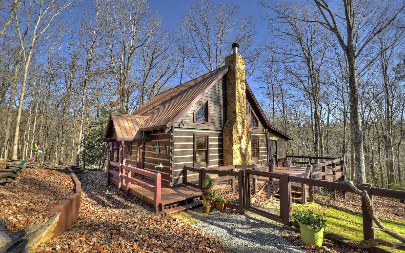 Welcome to your storybook mountain cabin. Classic, dovetail log cabin nestled on 6 nature-filled acres, this is a genuine Goldilocks special – not too big or little but just right! Cozy & comfortable at just under 1200 sf, the cabin features: well-designed 2BR/2BA, easy to expand floor plan; mellowed wood interior & hardwood floors; dramatic open-beam cath. ceil.; wood-burning fp for snug winter days; ceiling fans for refreshing summer breezes; spacious screen porch for indoor-outdoor living. Outside is an oasis of carefree naturescaping; generous decks & campfire for entertaining; fenced area; detached 2-car gar. for vehicles, storage, workshop, studio, game rm or other creative uses. 6+ ac. consist of 3 adjoining 2-acre lots w/ cabin at center. Adjacent lots offer potential for expansion or development. Whether a picturesque vacation getaway, short-term rental property or yr-round retreat, your storybook mtn cabin awaits.