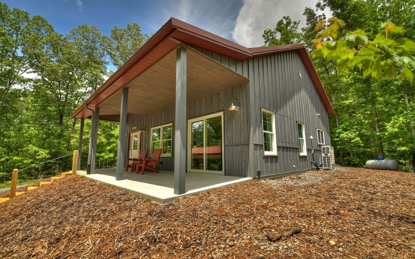 Nestled in the heart of Mineral Bluff between the beautiful mountain towns of Blue Ridge, Georgia, and Murphy, North Carolina, this cute as can be barn-style home is one you don’t want to miss. Whether you’re considering a home away from home or a guest home to accompany a new construction, this modern retreat offers a full kitchen open to the living room, one-bedroom, one-bathroom, full laundry and utility room, and the perfect front porch to enjoy the great outdoors. In addition, this home features a detached carport with storage and is extremely low maintenance with the metal exterior and wooded acreage. Converted from a building to living quarters, everything in the home is brand new. Don’t miss out on this cozy dreamer!