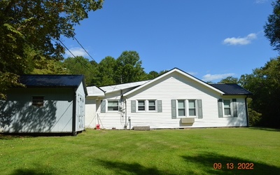 This lovely 1947 farmhouse sits on a lush pasture and wooded 6.71 acre lot. A lovely branch runs on the side of the property. The house has a new metal roof, updated appliances, updated bath that is handicapped accessible. It has upgraded windows and outside doors. It comes with a full generator. Very private property.