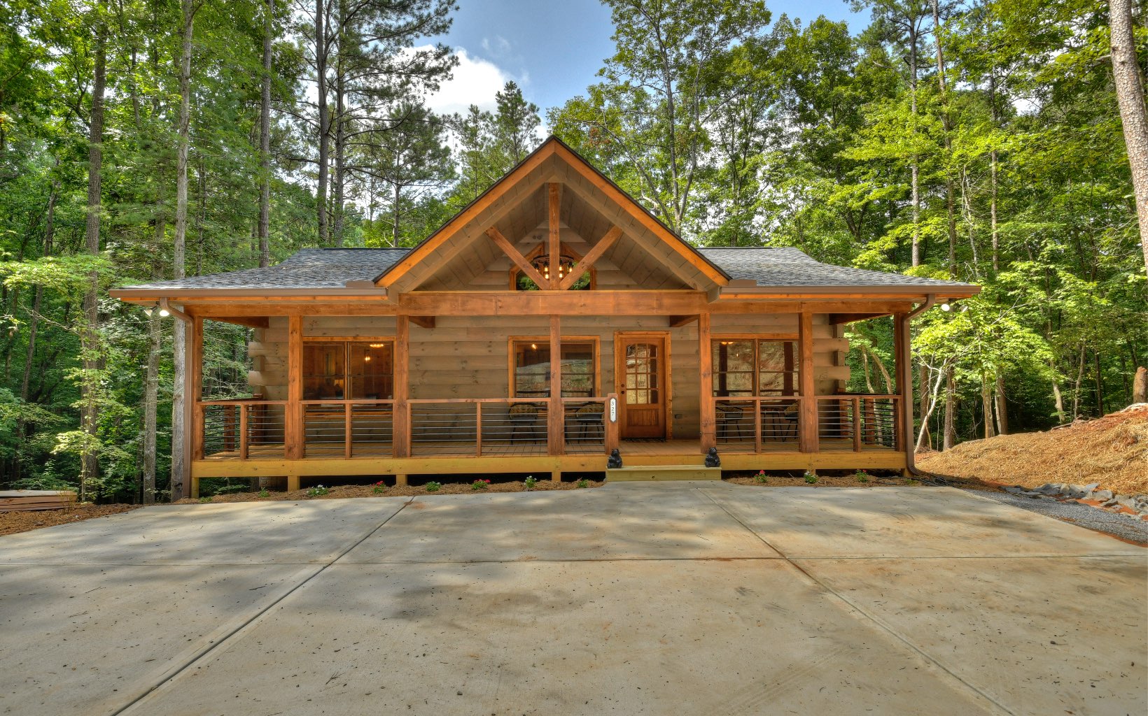 NEW PRICE ON THIS BEAUTIFUL AND TRANQUIL NEW CONSTRUCTION TRUE LOG CABIN! Beautiful wood finishes throughout including circular saw hardwood flooring and cabinetry. Sandstone granite countertops and unique rustic lighting help give this cabin a mountain touch you will fall in love with. Lots of windows provide natural lighting that showcases the detailed finishes such as a rock fireplace that extends to the beamed ceilings with a large, open living area. Large, oversized covered porches with vaulted ceilings add to the outdoor space of this cabin on one of the most beautiful private and wooded lots in Coosawattee. The large backyard is perfect for outdoor activities, enjoying nature, and enjoying the sounds of the Coosawattee River. This cabin is nestled among towering hardwood trees & close to downtown Ellijay. Close to downtown Ellijay, vacation rentals allowed, and lots of amenities in this gated community!