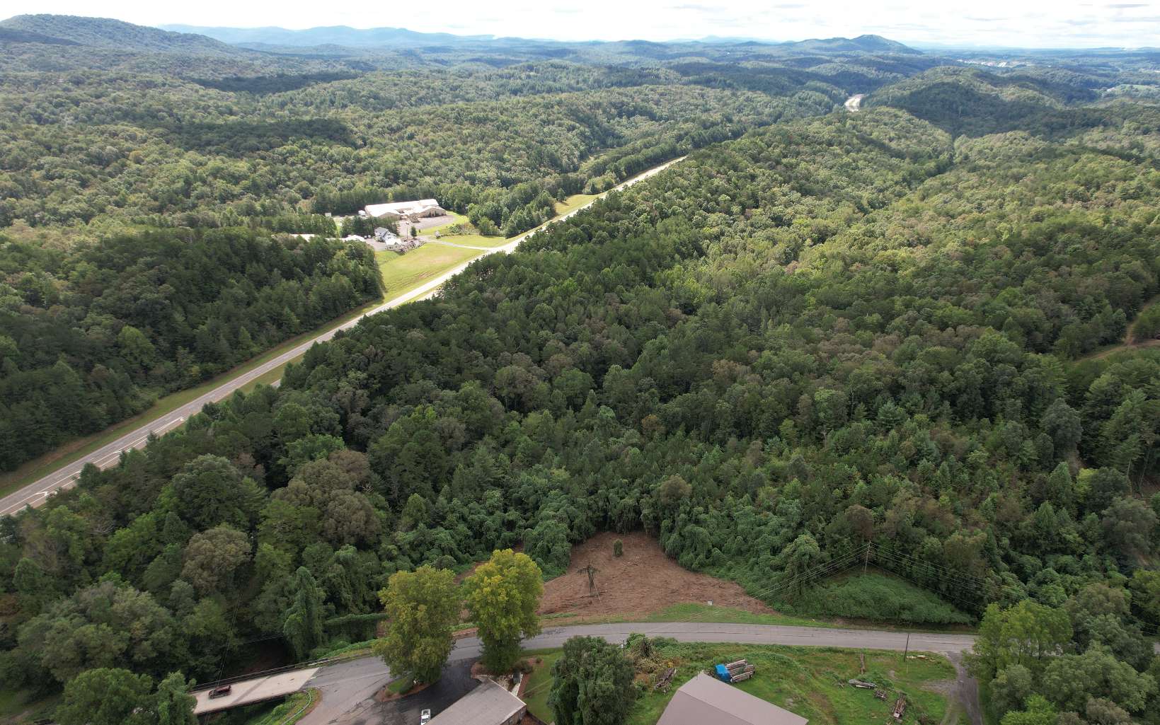 WOW! What a deal on commercial land. Right off of highway 515 this 12 acre track is sloped, but with some fill dirt and grading you would be sitting on a steal of a deal. Zoned R3, so bring your ideas. This lot is across the street from an event center and a daycare. Within minutes of Downtown Ellijay and visible from highway 515.